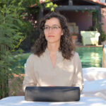 Noelia Otero sentada en jardín de una vivieda con mirada fija en un punto diferente al objetivo de la cámara